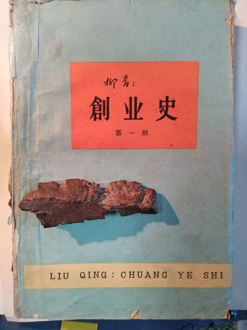 長篇小說《創(chuàng)業(yè)史》（第一部）書影與柳青曾收藏的彈片。 （文金 攝）